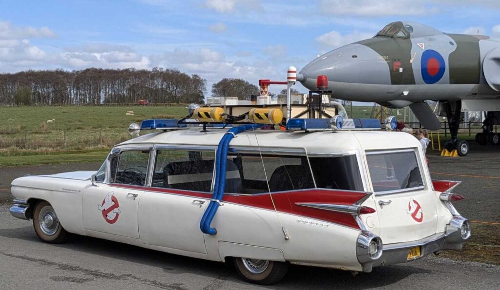 Driver side view of Ecto-1 with the Vulcan in the background.