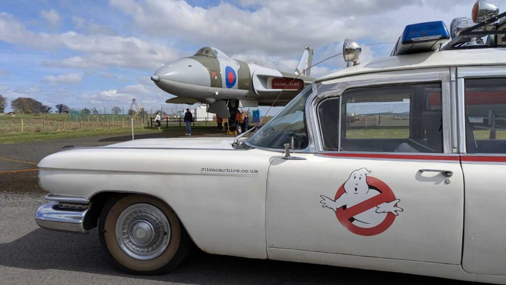 Driver side view of Ecto-1 with the Vulcan in the background.