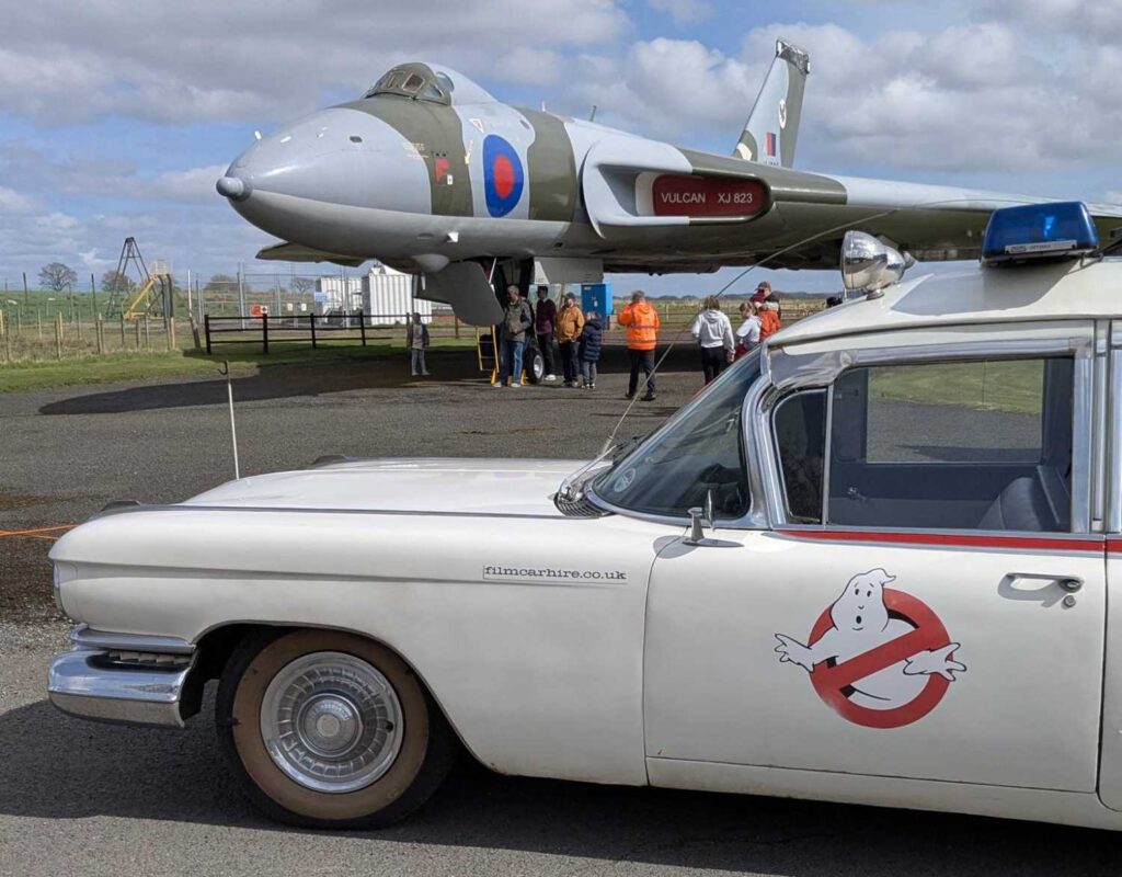 Driver side view of Ecto-1 with the Vulcan in the background.