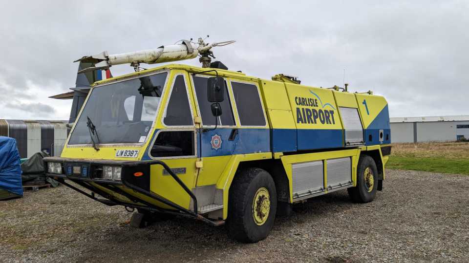 Side view of the Simon Gloster Faro Protector II in yellow with a blue stripe down the side.